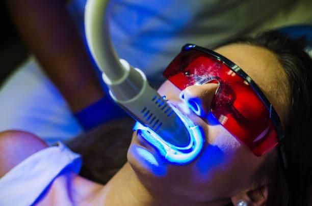 a woman having her teeth whitening procedure at the dentist